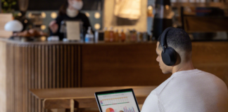Man wearing headphones while studying in cafe