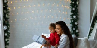 Image of a mom hugging a child with a gift in hand.
