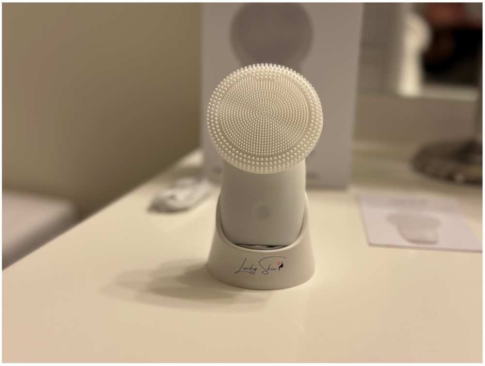 Lucky Skin Brush on charging dock placed on bathroom counter.