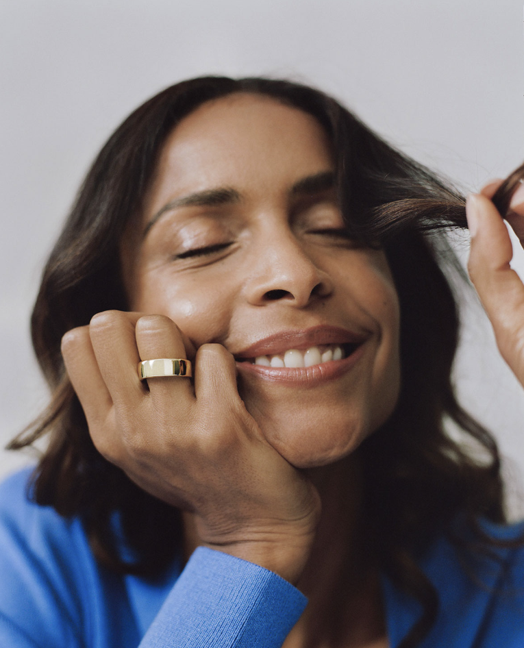 Woman smiling with her eyes closed wearing an Oura Ring