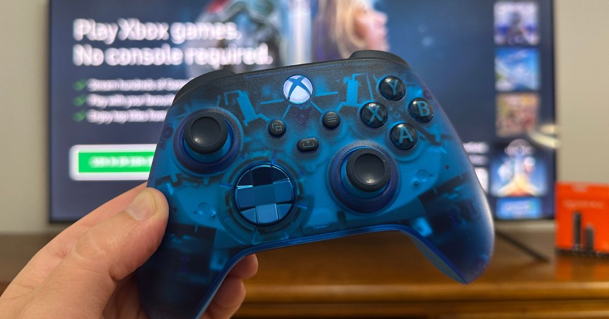 La télécommande Xbox avec l'application Xbox de l'Amazon Fire TV Stick ouverte derrière elle.