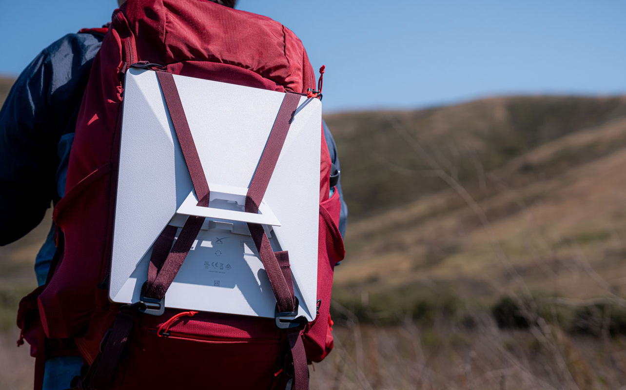 Une personne transportant la trousse Starlink Mini sur son sac à dos