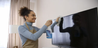 Woman cleaning her TV screen with a microfibre cloth.