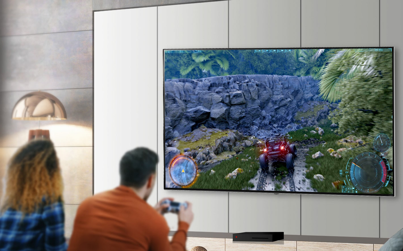 Couple playing video games on a wall-mounted TV.