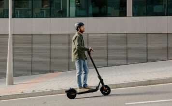 A man on the street with an electric scooter