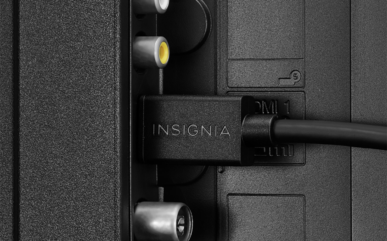 An Insignia HDMI cable plugged into the side of a TV.