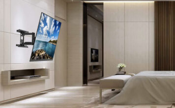 A TV mounted to the wall in a bedroom using a Kanto wall mount.
