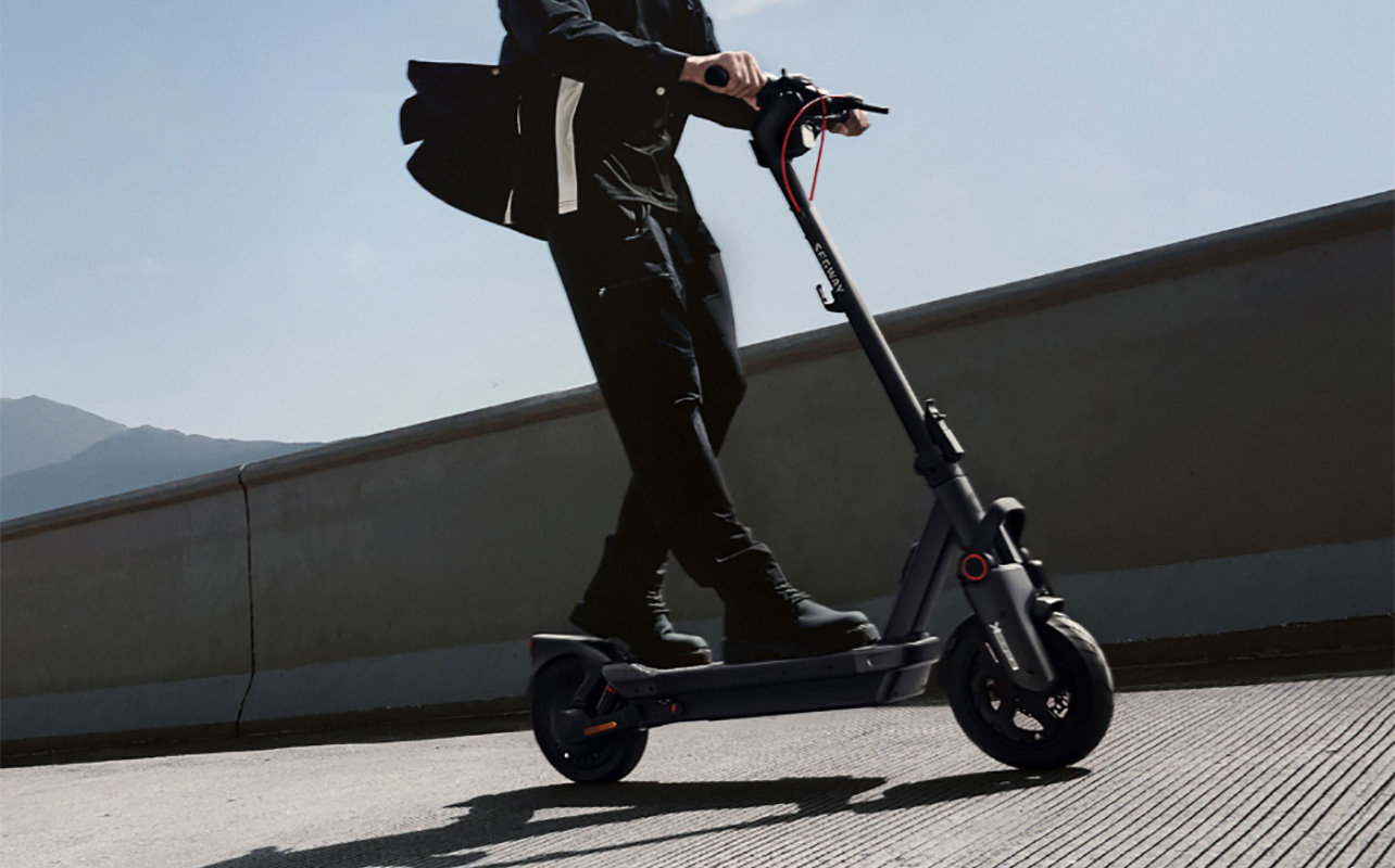 Les jambes d'un homme qui roule sur une trottinette électrique Ninebot Max G3 de Segway.